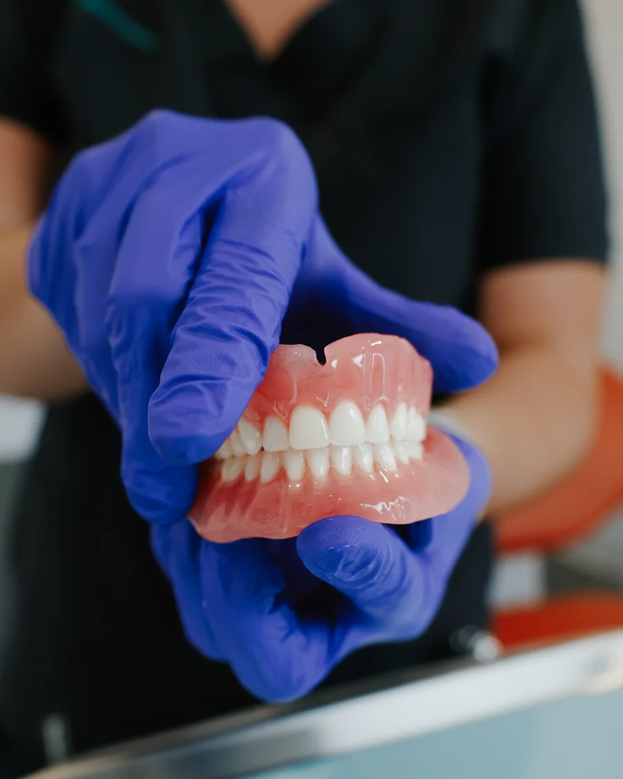Denturologue présentant une prothèse dentaire complète
