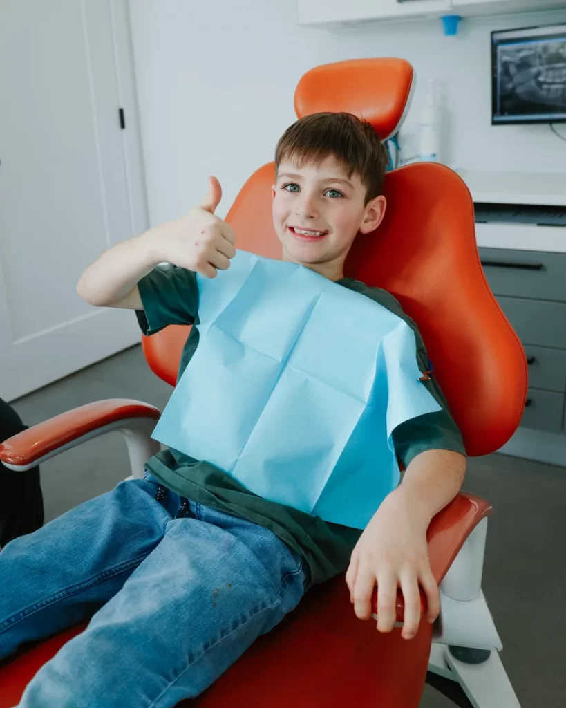A smiling child giving a thumbs-up in the dentist’s chair — Go Dentiste, dentist for children in Valleyfield and Vaudreuil-Dorion
