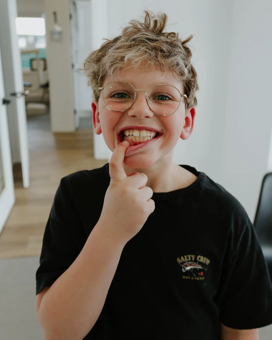 Un garçon montre fièrement ses dents