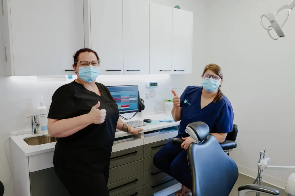 Two team members giving a thumbs-up in a dental treatment room — Go Dentiste, dentist in Valleyfield and Vaudreuil-Dorion
