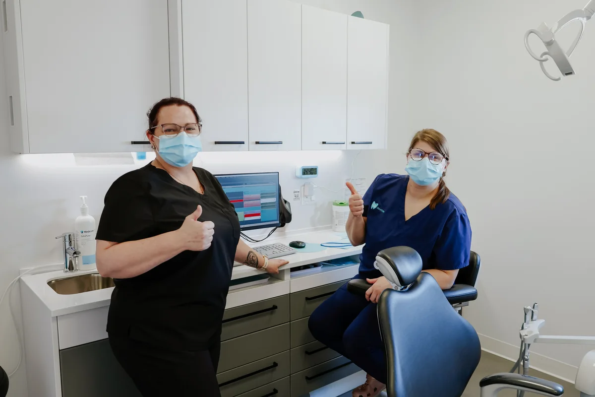 Deux membres de l'équipe Go Dentiste, pouce levé, dans une salle de soins
