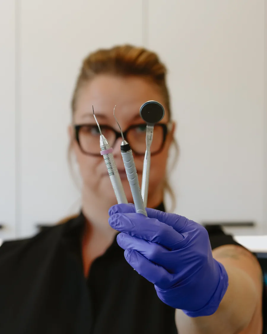 Instruments d'examen dentaire présentés par une membre de l'équipe