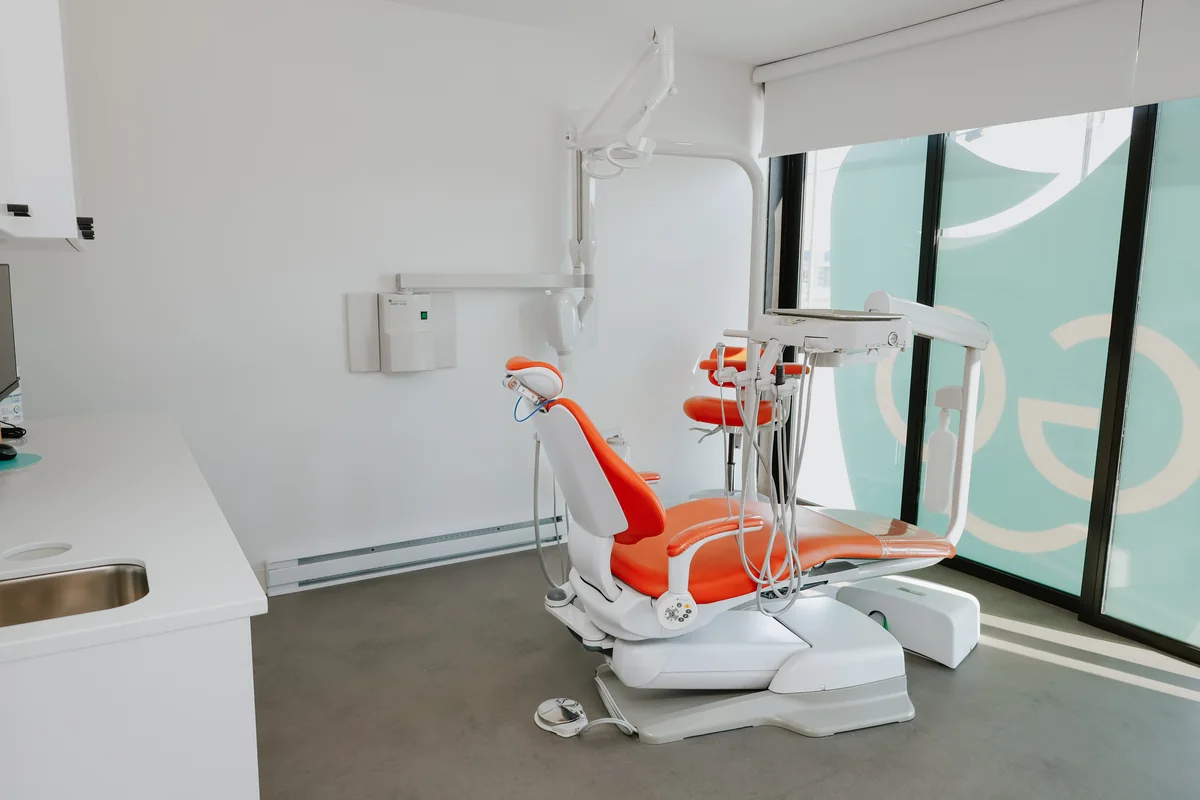 Salle de soins lumineuse avec fauteuil orange, clinique Go Dentiste
